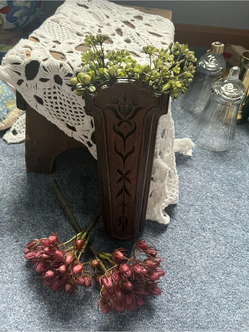 Carved Dark Wood Wall Pocket Vase will include a sprig of greenery